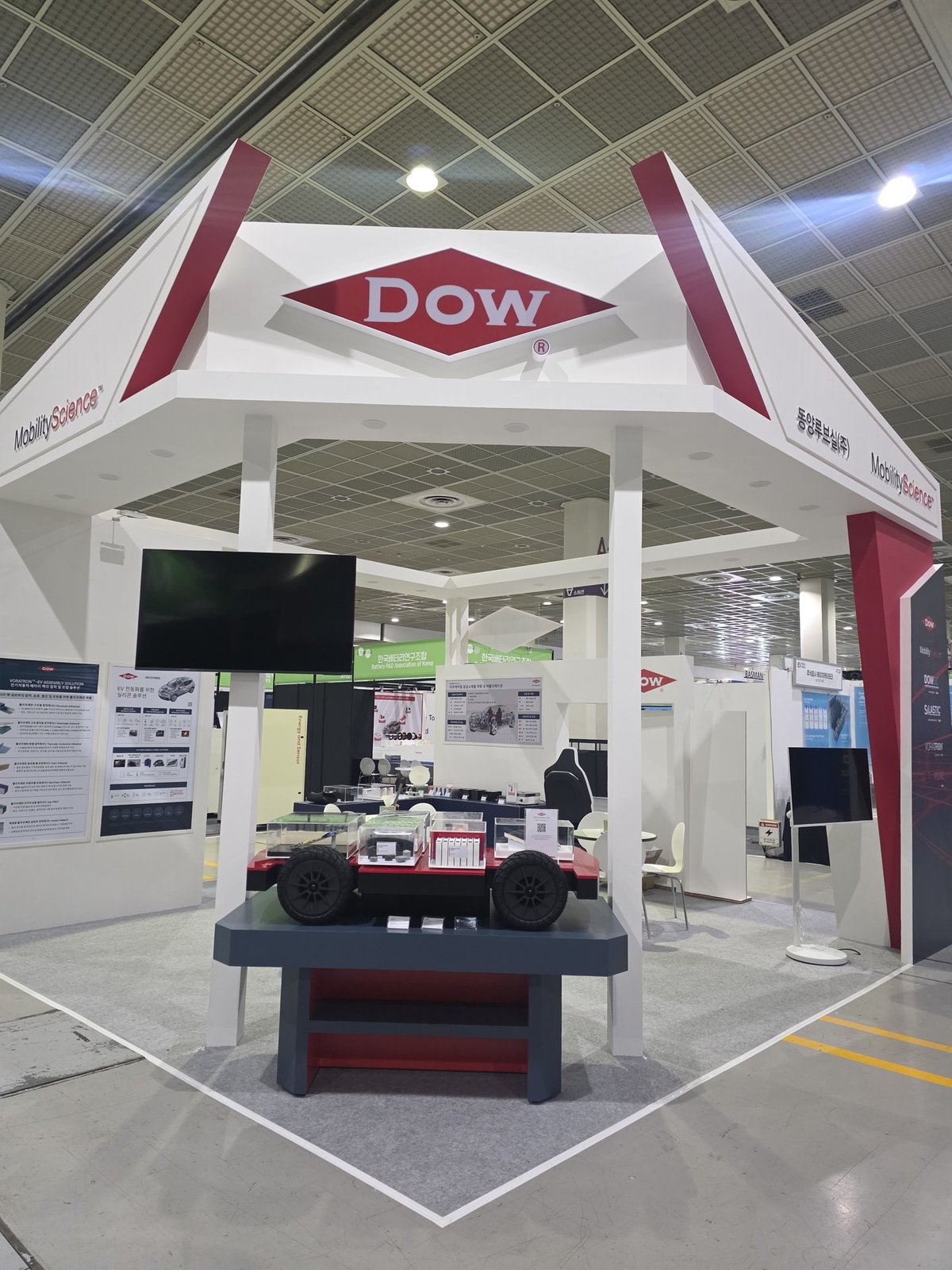 사람이 없는 Dow 부스의 전시대와 전기차 모형